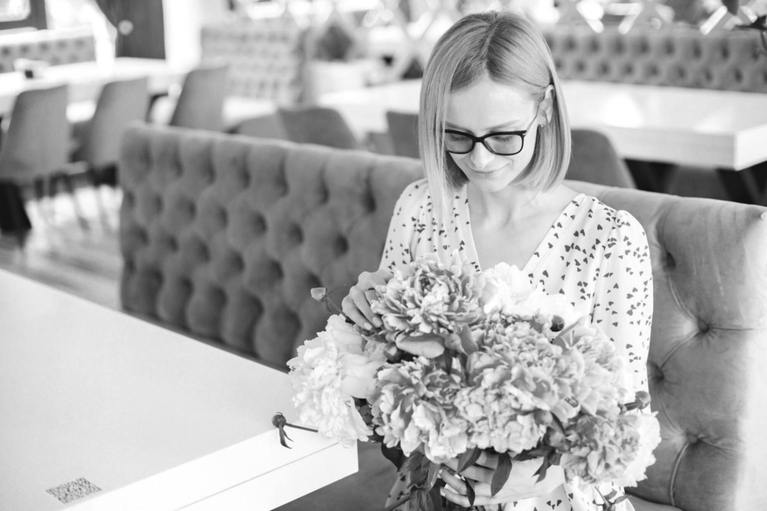 Professional floral arrangement workspace with various flowers and design tools